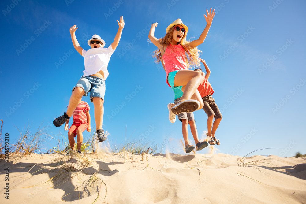 一群孩子从沙丘上跳起来