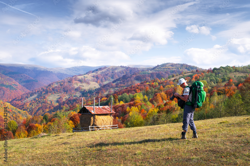 摄影师拍摄雾蒙蒙的山峰和橙色树木的秋季景观。乌克兰喀尔巴阡山