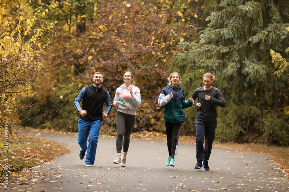 一群朋友在秋季公园跑步