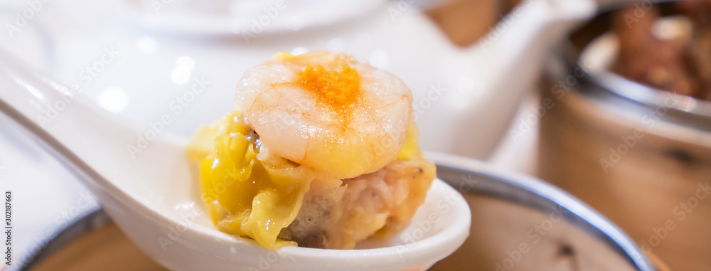 Siu Mai, one of Dim Sum yum cha, pork and shrimp steamed dumplings on restaurant house white backgro
