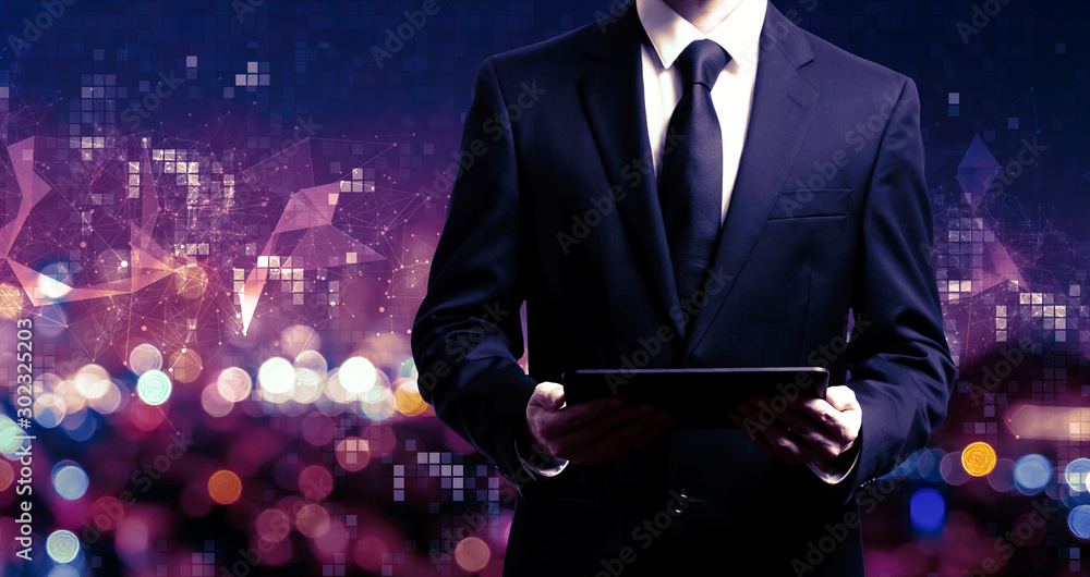 Businessman holding a tablet computer on night city background