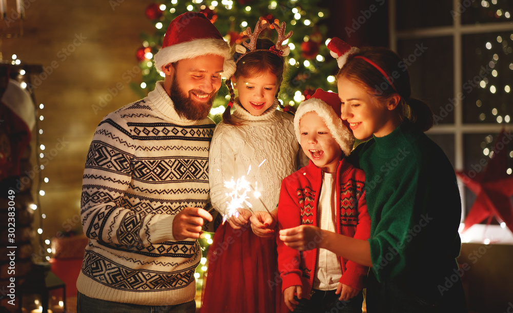 幸福的家庭，母亲、父亲和孩子们用灯光庆祝圣诞节和新年。