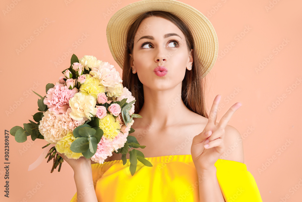 美丽的年轻女子拿着一束康乃馨花，在彩色背景上展示胜利的姿态