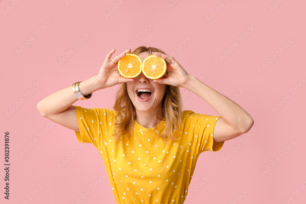 Funny mature woman with cut orange on color background