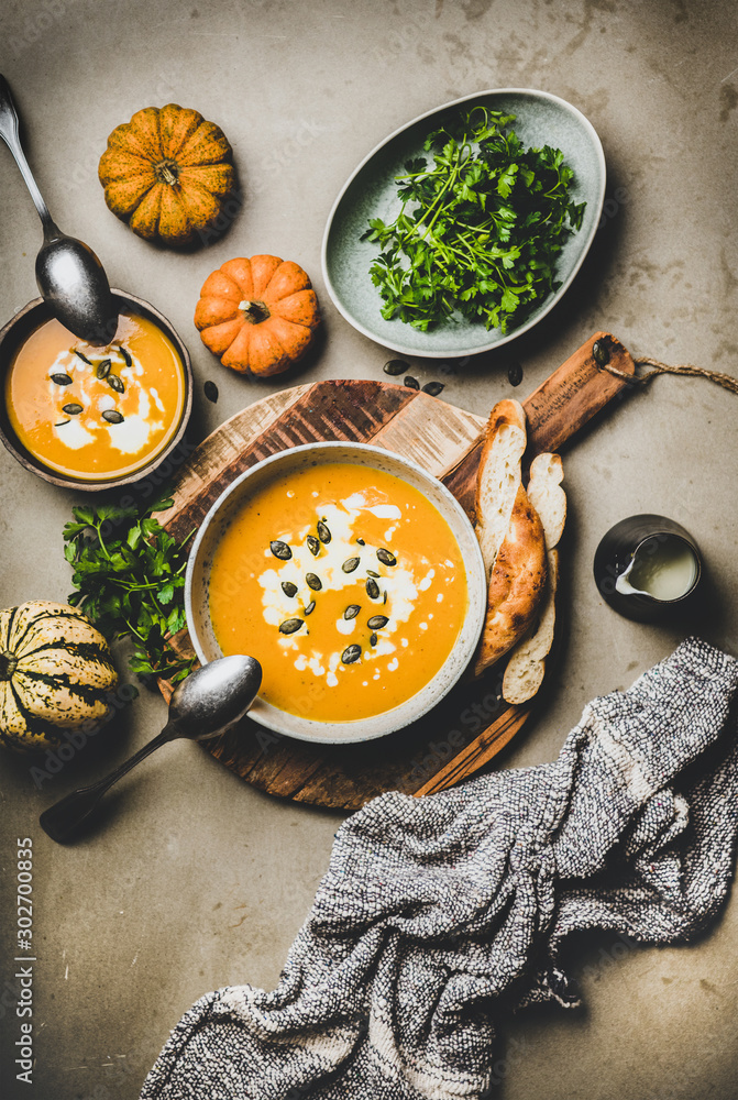 秋冬温暖的时令大餐。南瓜汤配种子、欧芹、奶油和面包