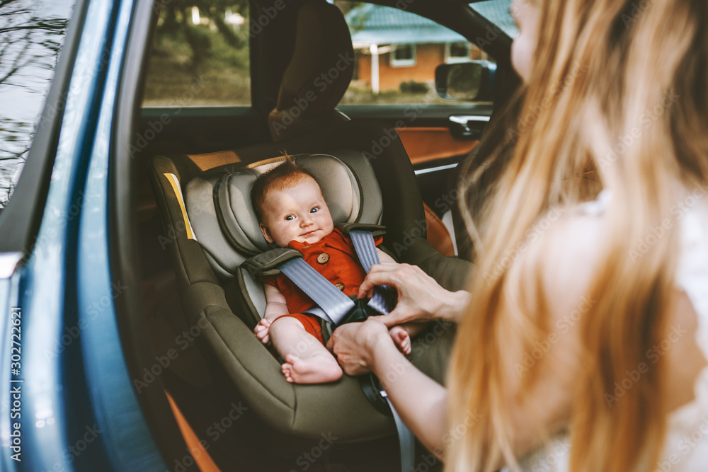 母亲把婴儿放在安全的汽车座椅上家庭生活方式育儿交通公路旅行度假