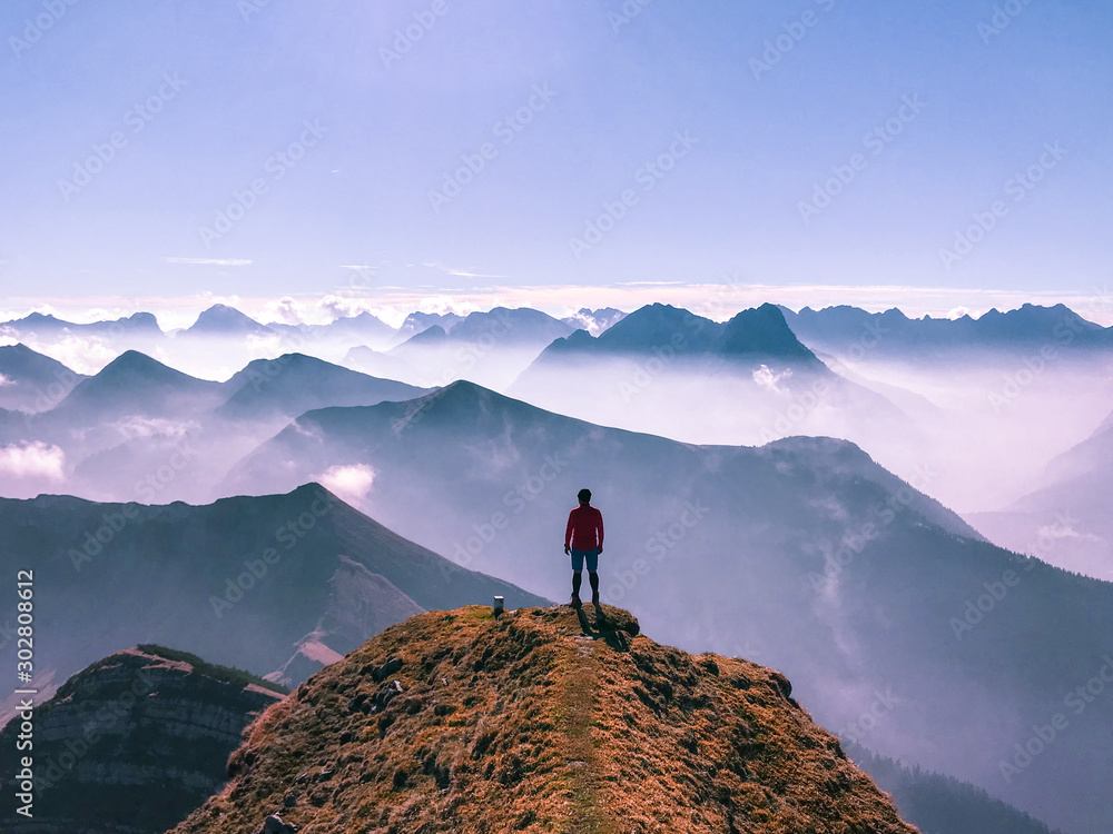 A man stands atop a mountain in the Alps in Germany