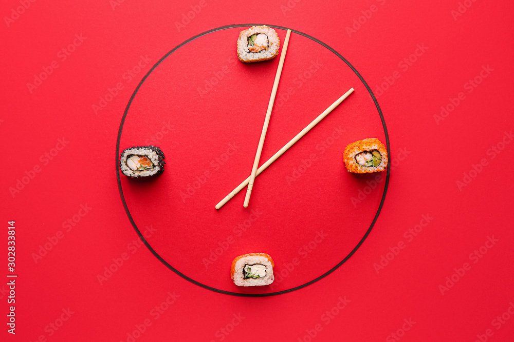 由美味的寿司和筷子制成的彩色背景创意时钟