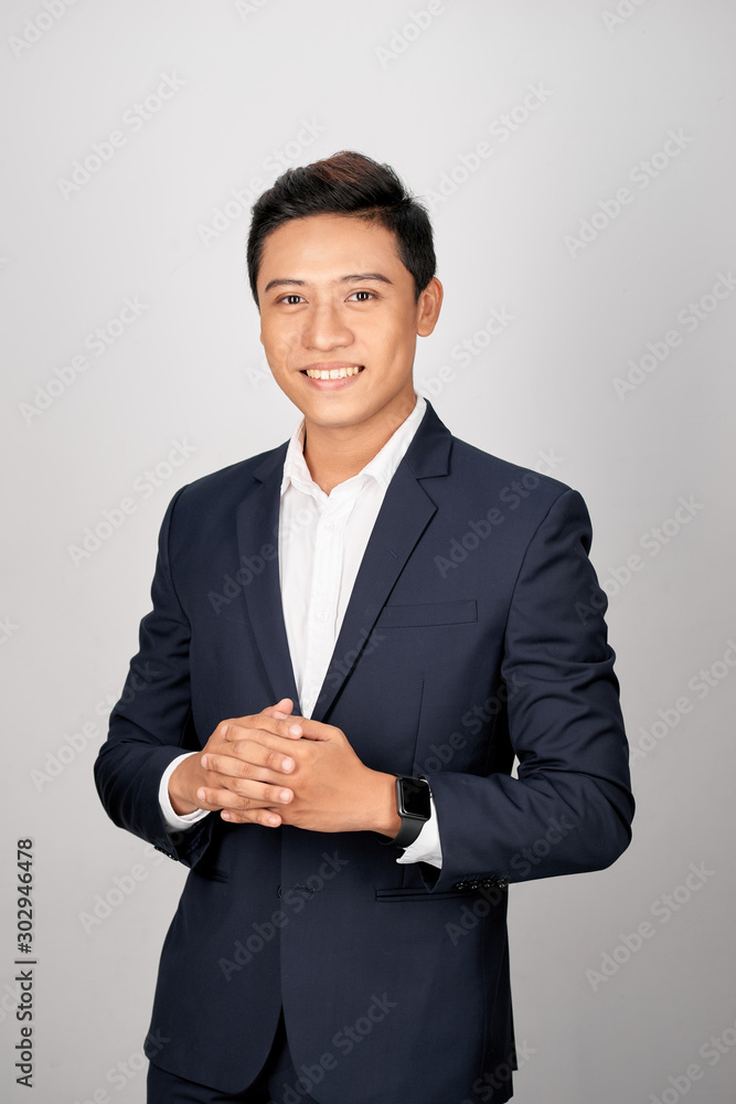 Asian man in office suit posing on white background