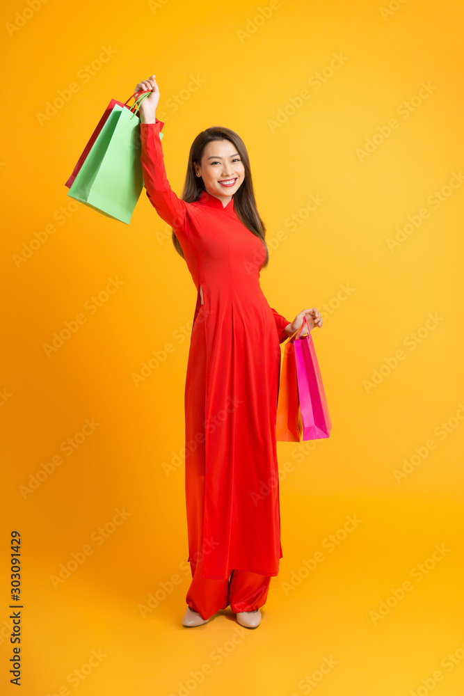 越南妇女手里拿着购物袋，站着不动，笑容满面