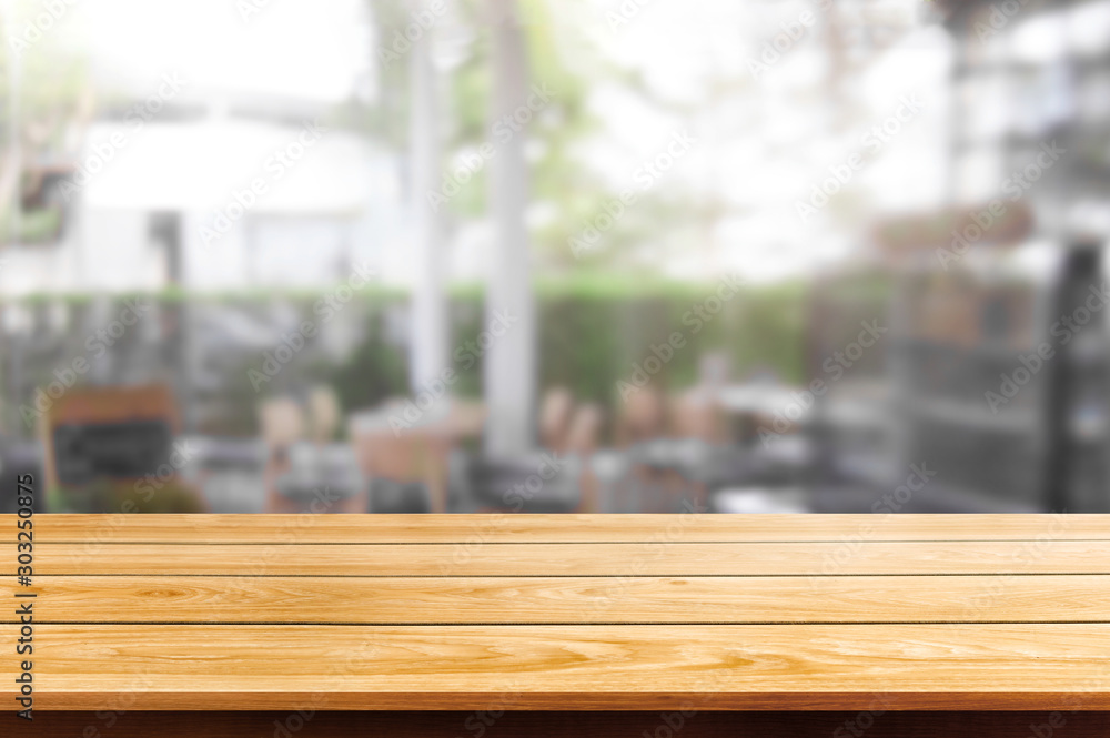 Wood table in blurry background of modern restaurant room or coffee shop with empty copy space on th