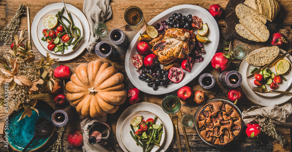 感恩节派对餐桌设置。整只烤鸡、蔬菜、无花果派、秋季油炸