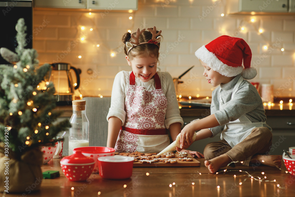 happy children boy and girl bake christmas cookies