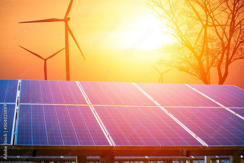 太阳能电池板和风力涡轮机，在美丽的日出或日落背景下，清洁电力