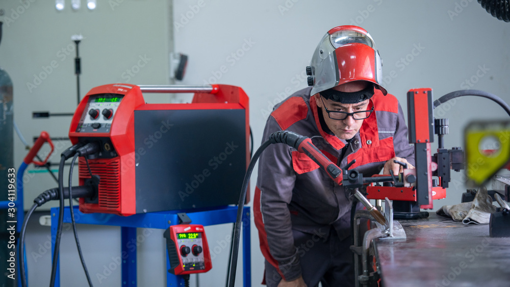 专业焊工在工厂检查工业汽车点焊机。