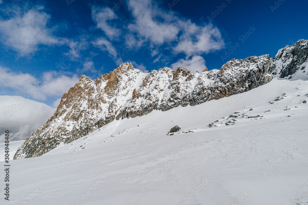 冬季条件下的高山山脊。冰雪覆盖的岩石山脊。冬季高山景观