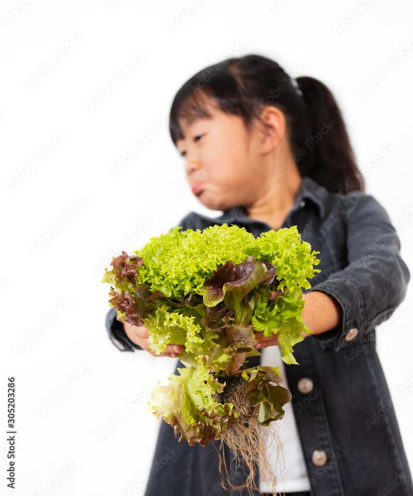 The salad that children do not like girl Asianis holding a green salad that he doesnt like, healthy