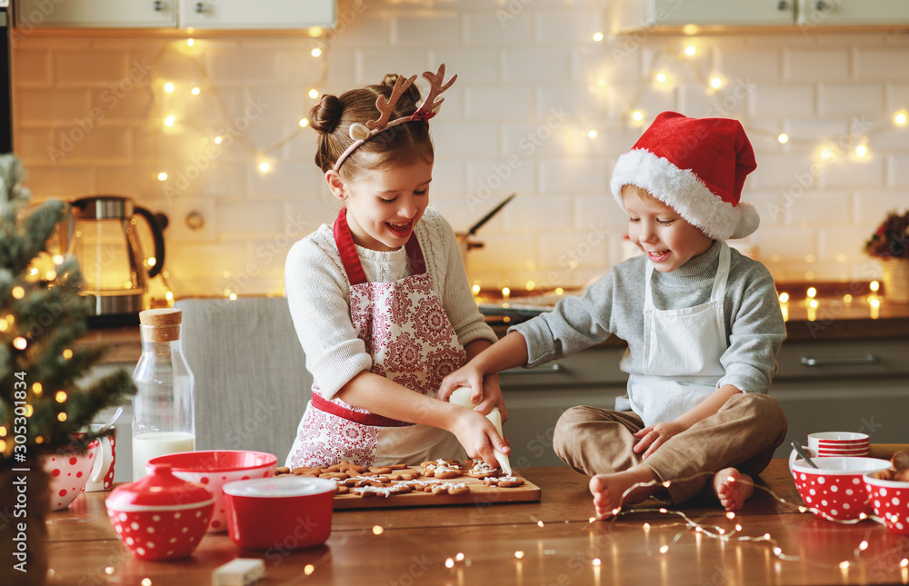 快乐的孩子男孩和女孩烤圣诞饼干。