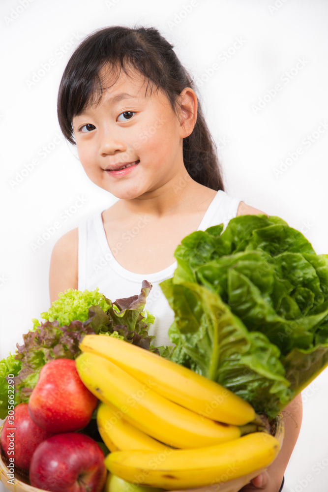 一个亚洲女孩在白色背景下拿着健康的水果和蔬菜节食的照片。