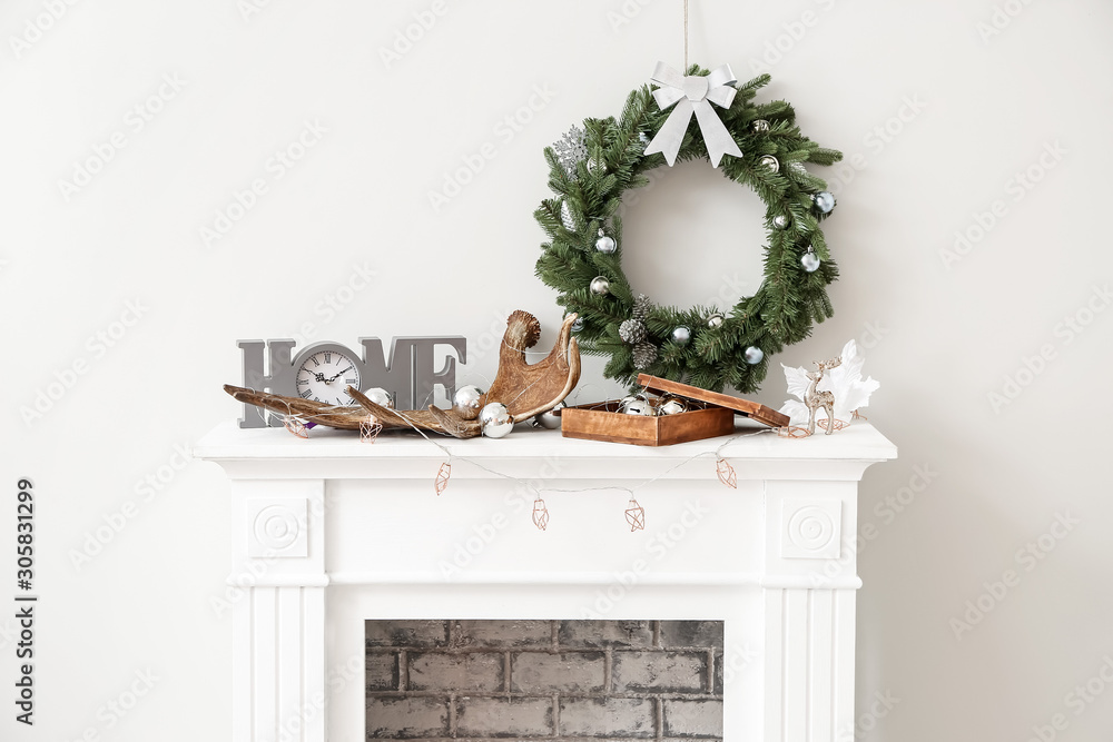 美丽的圣诞花环挂在壁炉附近的墙上，装饰精美