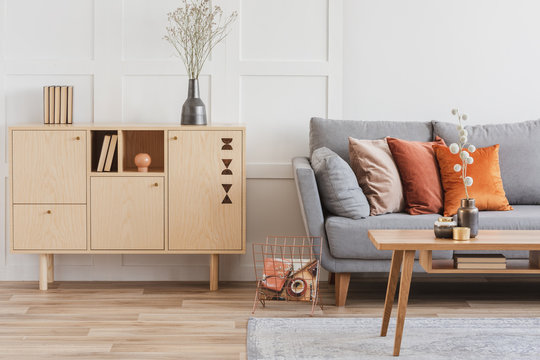 木质家具和灰色斯堪的纳维亚沙发，客厅内部有枕头