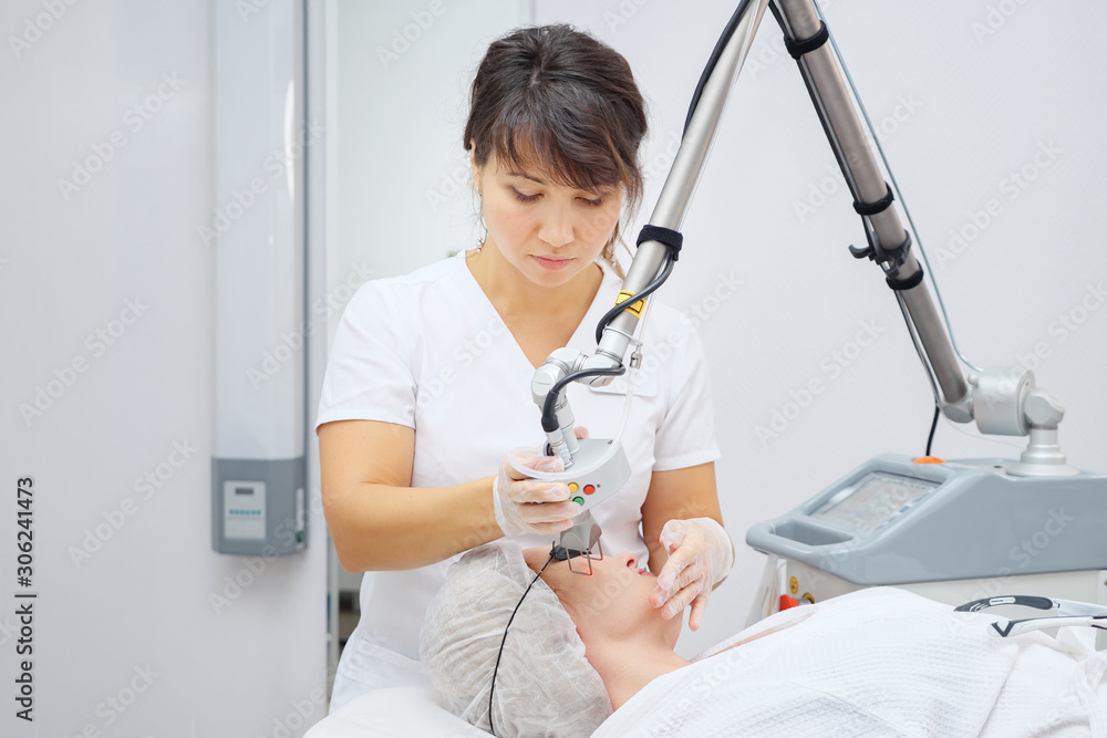 医疗沙龙女员工使用有效的钕激光去除年轻患者不需要的疤痕