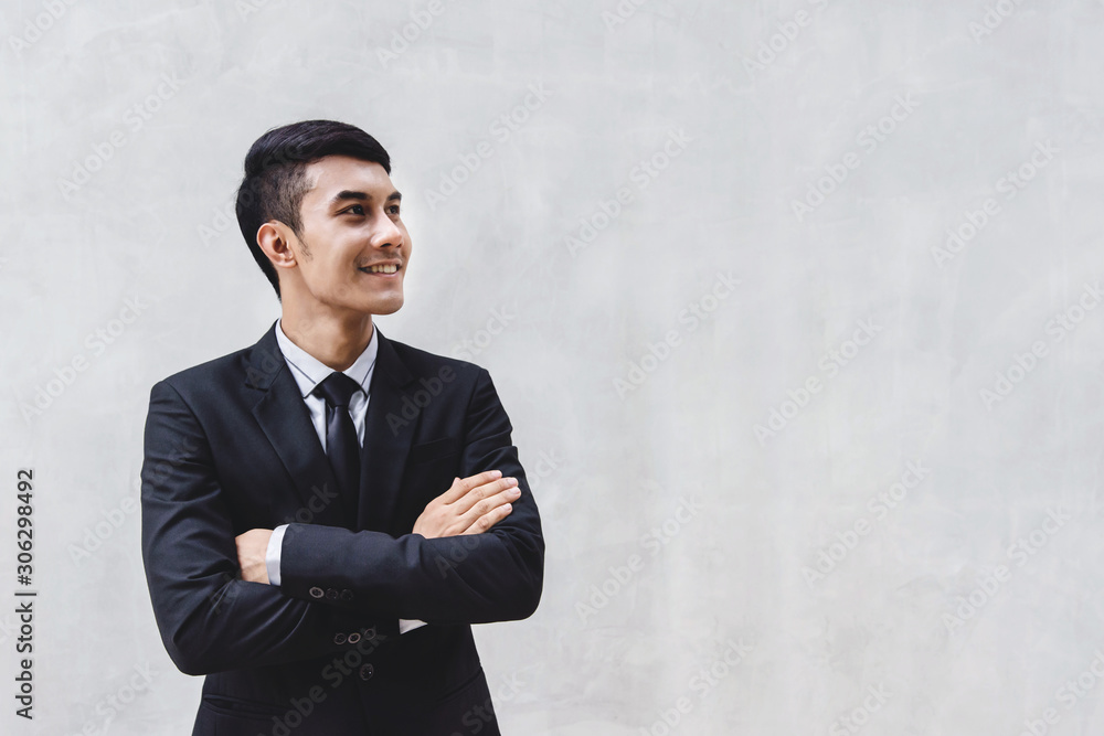 Portrait of Happy Businessman in Black Formal Suit. Standing by the Wall, Crossed Arms and Looking a