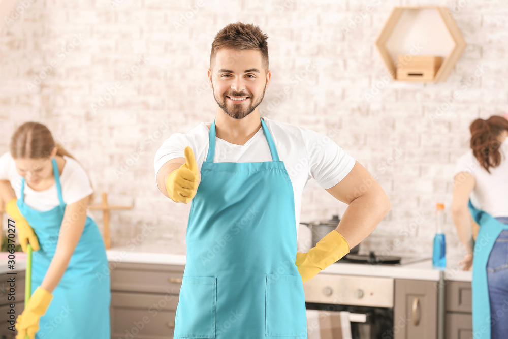 Male janitor showing thumb-up gesture in kitchen