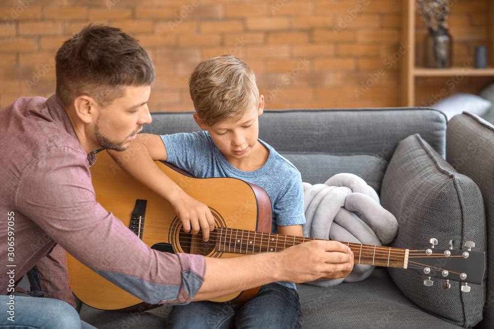 父亲在家教他的小儿子弹吉他