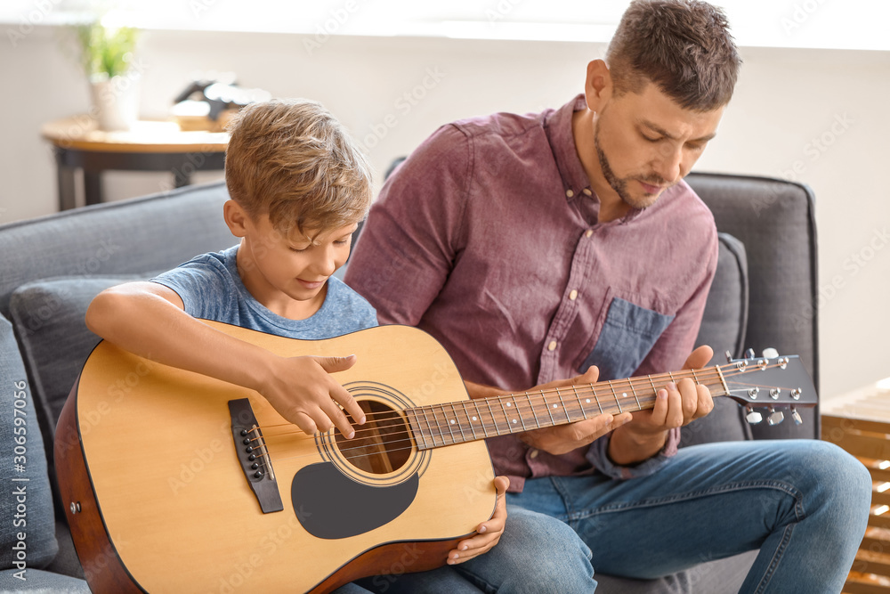 父亲在家教他的小儿子弹吉他