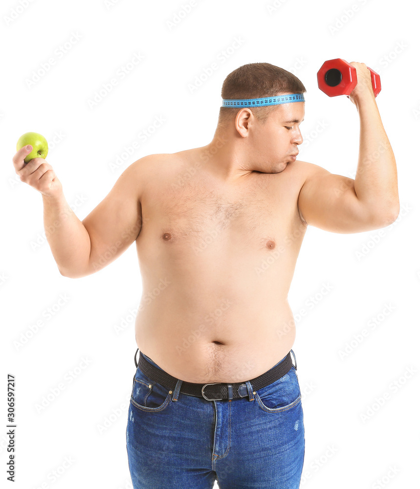 超重男子，白色背景上有哑铃、卷尺和苹果。减肥概念