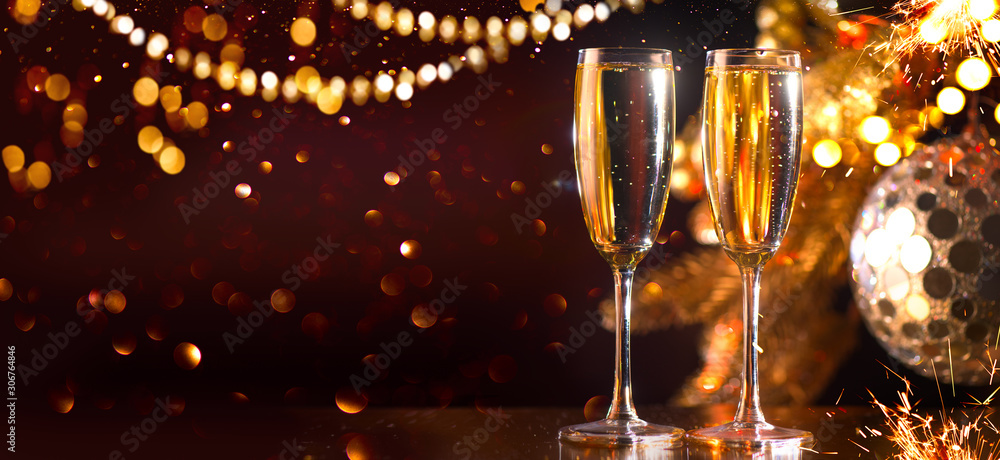 Holiday Champagne Flute over Golden glowing background. Christmas and New Year celebration. Two Flut
