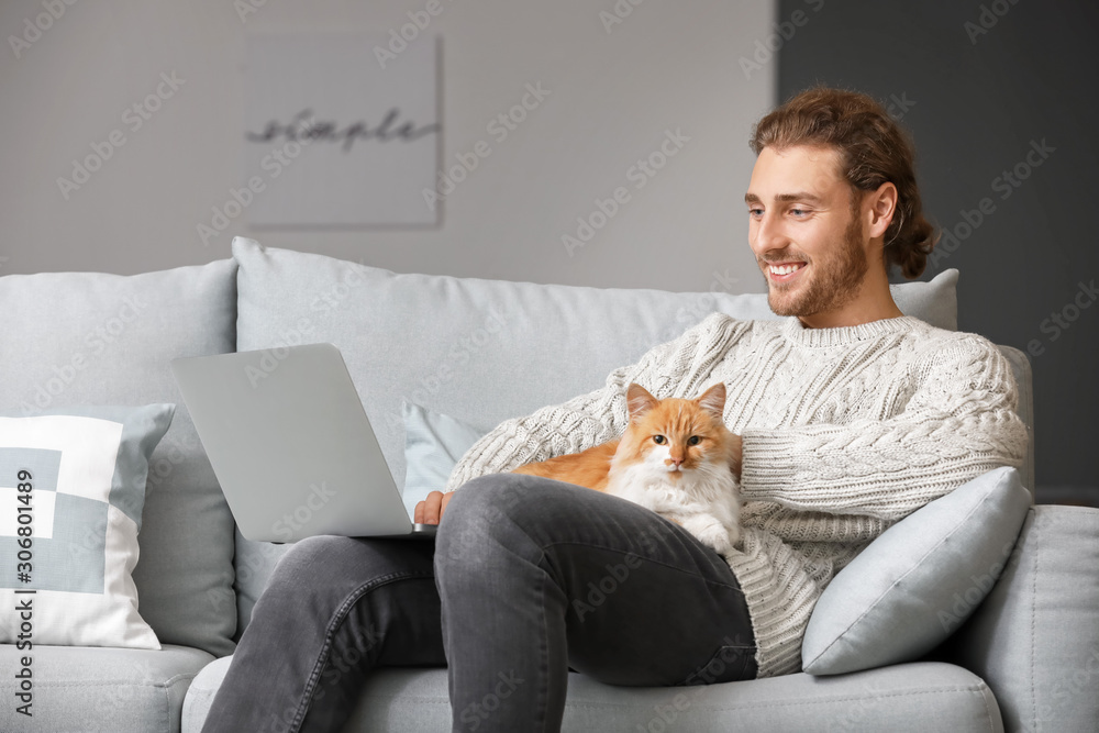 家里有笔记本电脑的男人和他可爱的猫