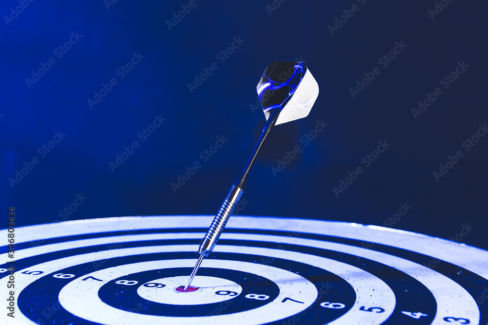 Dartboard with hit bullseye on dark background，特写