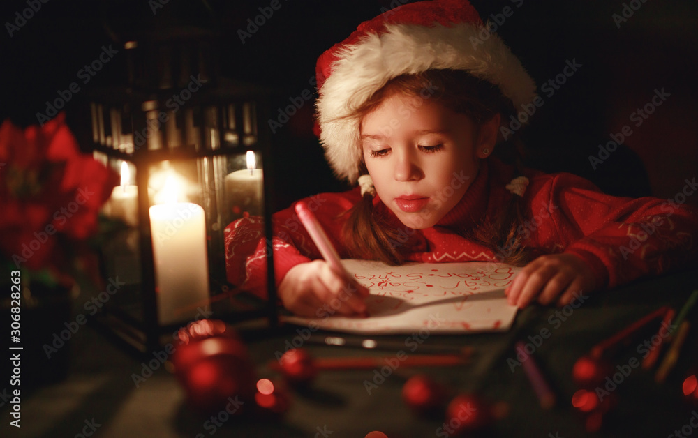 happy child girl writing letter santa home near Christmas tree.