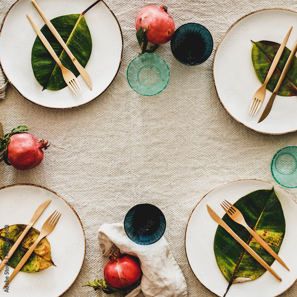 秋季或秋季餐桌，用于节日晚餐。平面餐具，上面有水果和树叶。