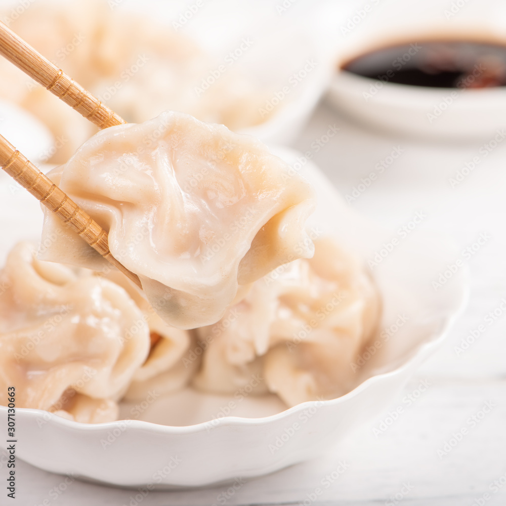 Fresh, delicious boiled pork, shrimp gyoza dumplings on white background with soy sauce and chopstic