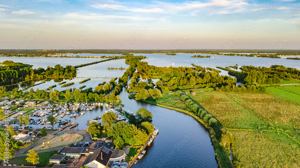荷兰典型景观的无人机鸟瞰图，包括运河、围堤水、绿地和农舍