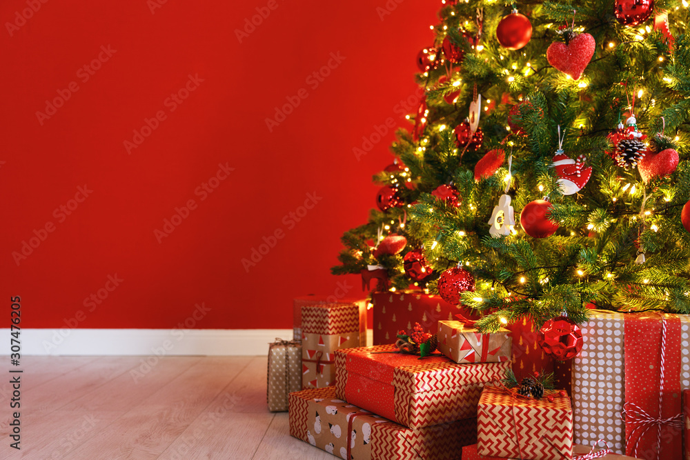 红色空墙背景上的圣诞树。