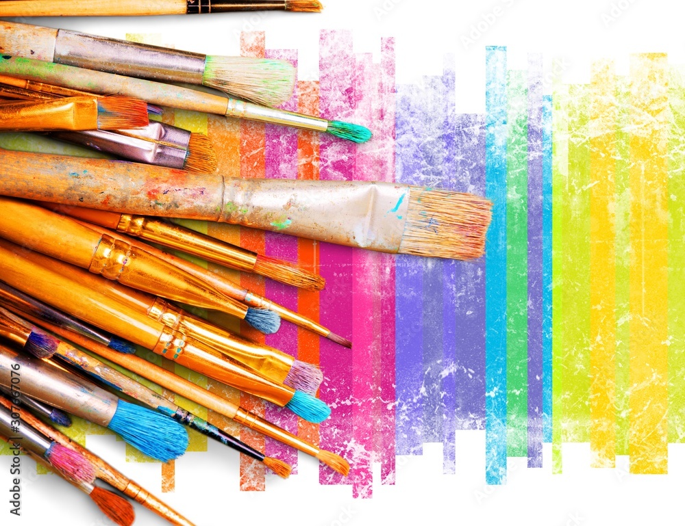 Multi-colored brushes of different thickness on the painted canvas