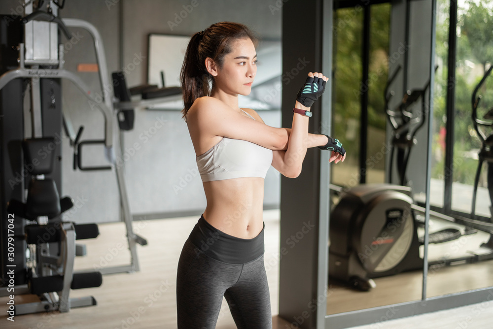 美丽的亚洲女人正在健身房锻炼