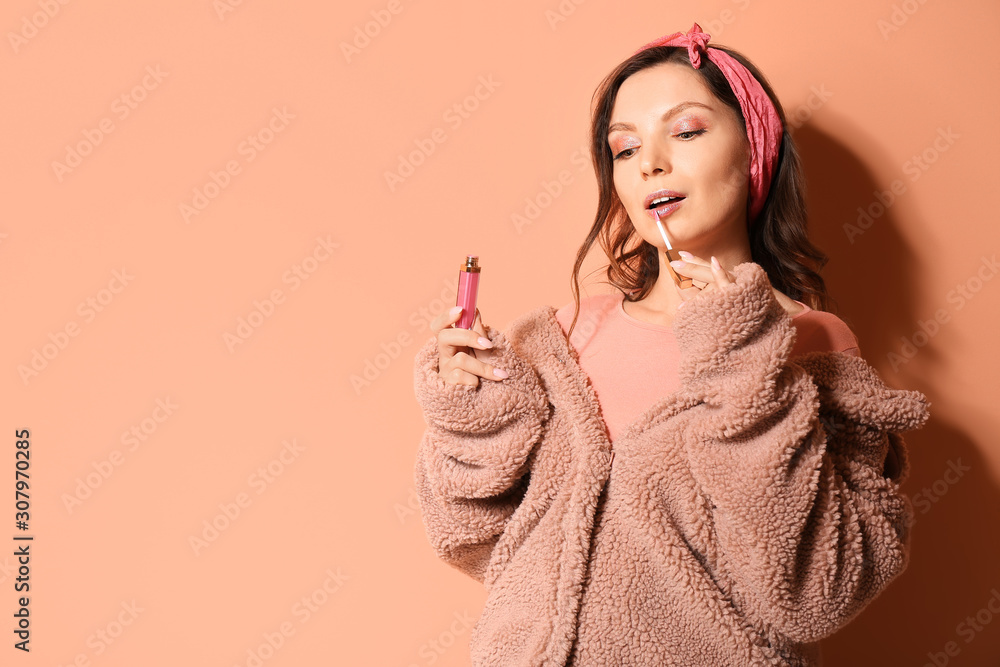 Fashionable young woman with lipstick on color background