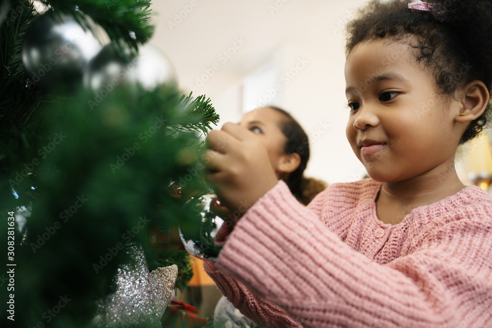 母女非裔美国女孩装饰圣诞树，布置圣诞礼