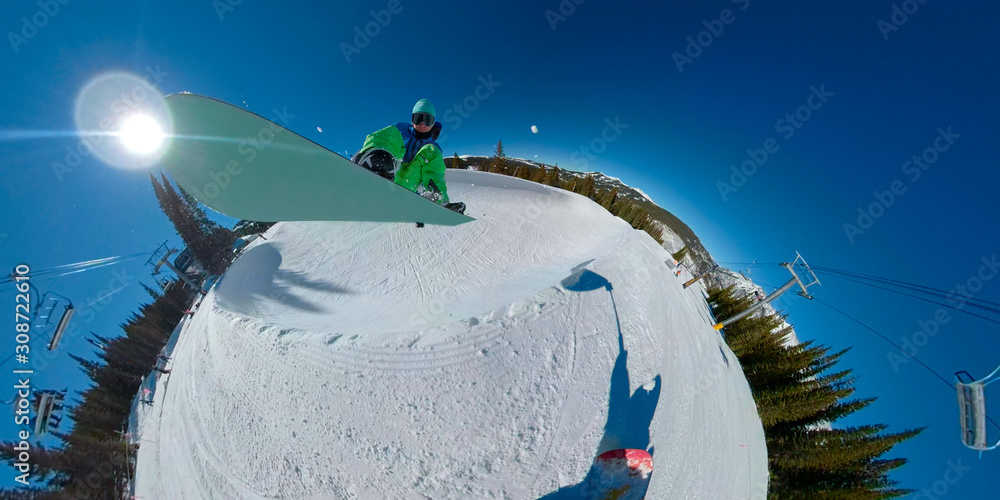 SELFIE: Snowboarder dude does a trick while jumping off the lip of a half pipe.