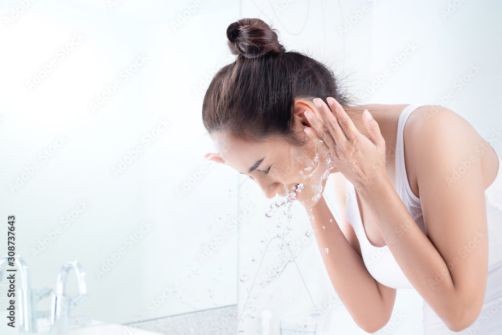 Beautiful woman washing face in the bathroom