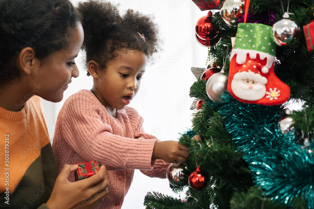 母女非裔美国女孩装饰圣诞树，布置圣诞礼