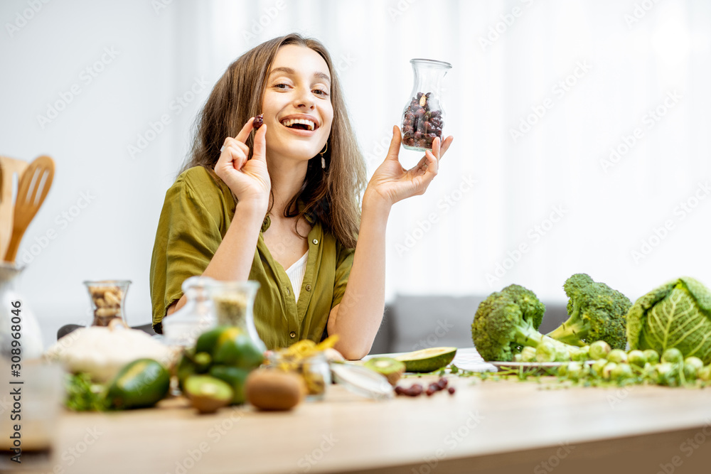 一个年轻快乐的女人的画像，桌上摆着干玫瑰果和很多健康的绿色食物。C
