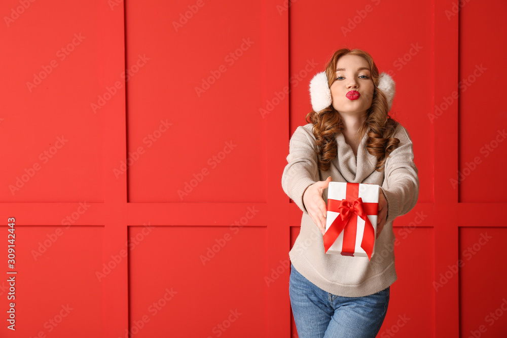 快乐的年轻女人，穿着冬装，背景是圣诞礼物