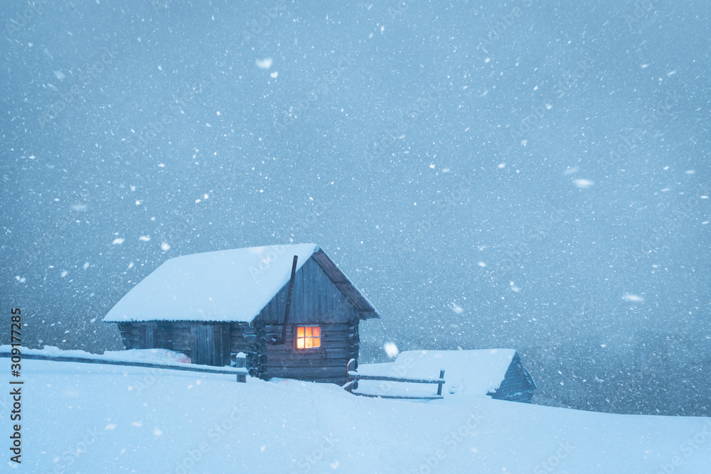 在雪山的暴风雪中有木屋的奇妙冬季景观。圣诞节假期和