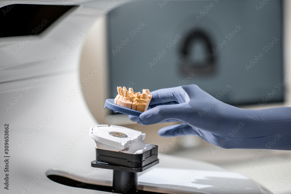 牙科技师在实验室将下颌模型放入三维扫描仪，特写